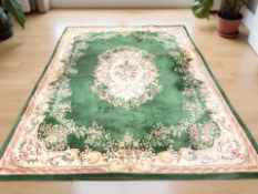 A machine made Chinese woollen carpet on green ground, 360 cm x 270 cm.