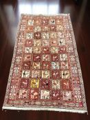 An eastern flatweave rug depicting stylised birds within a compartmentalised central field,
