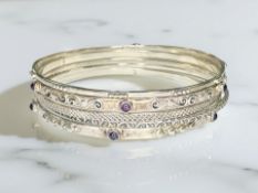 A stack of five bangles stamped '925 India', two set with amethyst cabochons, inner diameter 6.5cm.