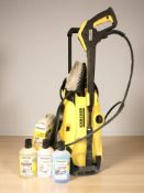 A Karcher K4 pressure washer, together with an extension hose and three bottles of fluid.