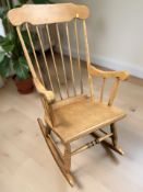 A reproduction beech spindle back rocking chair.