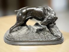 A cast and patinated bronze figure of a greyhound after Mene, width 23 cm.