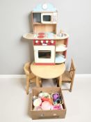 A child's table and two chairs, a further kitchen unit and a box of various kitchen toys.