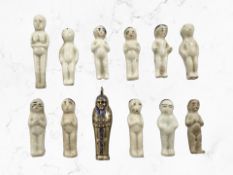 A group of antique 'Frozen Charlotte' charm figures and an Egyptian charm.
