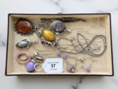 A group of silver/white metal gem-set pendants, including amethyst,