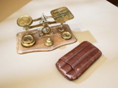 A set of Victorian postal scales with graduated weights and a vintage leather cigar case