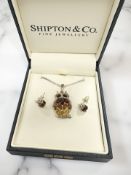 A silver and amber owl pendant and similar pair of ladybird ear studs