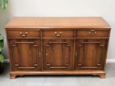 A reproduction yew wood sideboard,