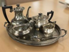 An EPNS twin handled serving tray containing a four piece tea service and several pieces of cutlery.