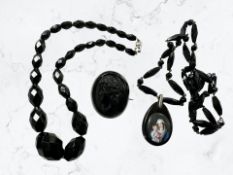 A group of antique jet jewellery to include two necklaces and a brooch.