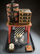 An oriental lacquered three division rice basket, together with a miniature three drawer chest,