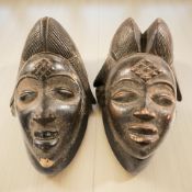 Two African carved hardwood wall masks, height 28 cm.