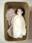 A wicker basket containing an antique Alt Beck & Gottschalk German bisque jointed doll,