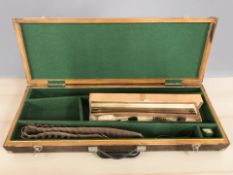 A gun case containing a canvas cartridge belt & gun cleaning kit