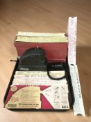 A MiniCine projector, with box and adapter cable, and a quantity of Minicine film strips.