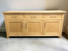 A contemporary pine effect sideboard fitted cupboards and drawers, 180 cm x 46 cm x 86 cm.
