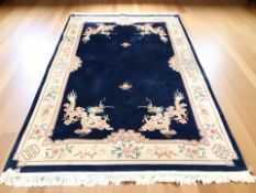 A Chinese woollen carpet on navy blue ground, 330 cm x 203 cm.