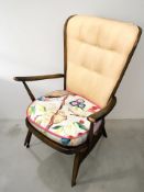 An Ercol stained elm spindle back lounge armchair.