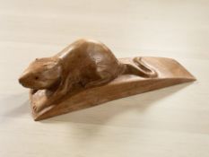 A carved wooden doorstop surmounted by a mouse, length 16 cm.
