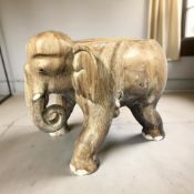 A carved hardwood elephant seat, length 63 cm.