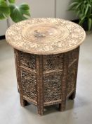 An Anglo-Indian heavily carved hardwood and brass inlaid circular occasional table,