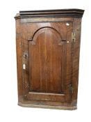 A George III oak single door hanging corner cabinet, height 93 cm.