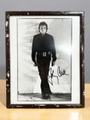 A monochrome photographic print of Johnny Cash, signed in black ink,