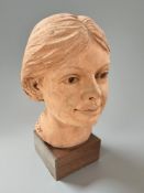 P Finch : A terracotta bust of a woman on square wooden plinth, signed and dated '99, height 27 cm.