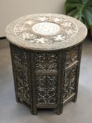 An Anglo-Indian heavily carved hardwood and brass inlaid circular occasional table,
