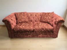 A Chesterfield style two seater settee in deep buttoned red floral upholstery,