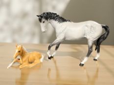A Beswick Spirit of Youth matt grey horse and a further recumbent palomino foal.