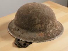 A 20th century British tin military helmet.