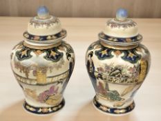 A pair of 20th century Japanese earthenware lidded temple jars, height 26 cm.