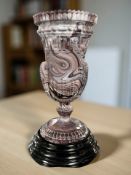 A Victorian purple slag glass vase on stepped black glass plinth, overall 21 cm high.