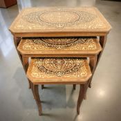 An Italian style nest of three marquetry inlaid occasional tables, width 65 cm.