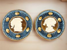 A pair of Austrian glazed relief wall plates depicting figures in profile, stamped 357 to reverse,
