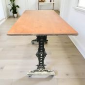 A pine rectangular pub table on cast iron support, 130 cm x 65 cm x 77 cm.