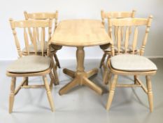A contemporary pine effect drop leaf kitchen table and a set of four chairs.