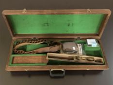 A gun case containing a leather cartridge belt, gun cleaning rods, slip on recoil pad,