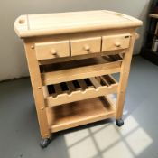 A contemporary kitchen butcher's block trolley on castors, with three drawers,