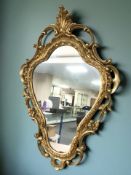 An ornate reproduction gilt mirror,