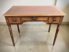 A Regency style mahogany three drawer writing table with tooled leather inset top,
