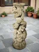 A weathered concrete garden bird bath column in the form of cherubs, height 79 cm.