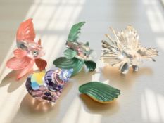 Three Swarovski crystal fishes (green example a/f), and a further sea shell ornament, tallest 5 cm.