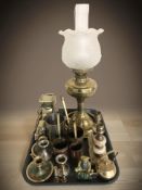 A brass oil lamp with frosted glass shade, further brass ornaments including a horse and carriage,