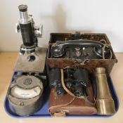 A bakelite military telephone in case, a pair of Noctovist II binoculars,
