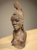 An eastern hardwood carving of a nude female in traditional headdress, height 64 cm.