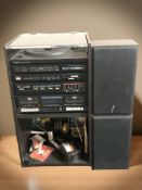 A record cabinet containing a Sanyo stereo music system GXT250, a quantity of cassettes,