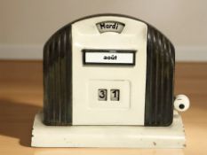 A French Art Deco brass and enameled metal desk calendar, width 14 cm.