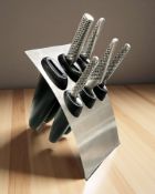 A knife block containing a part set of Global stainless steel chef's knives.
